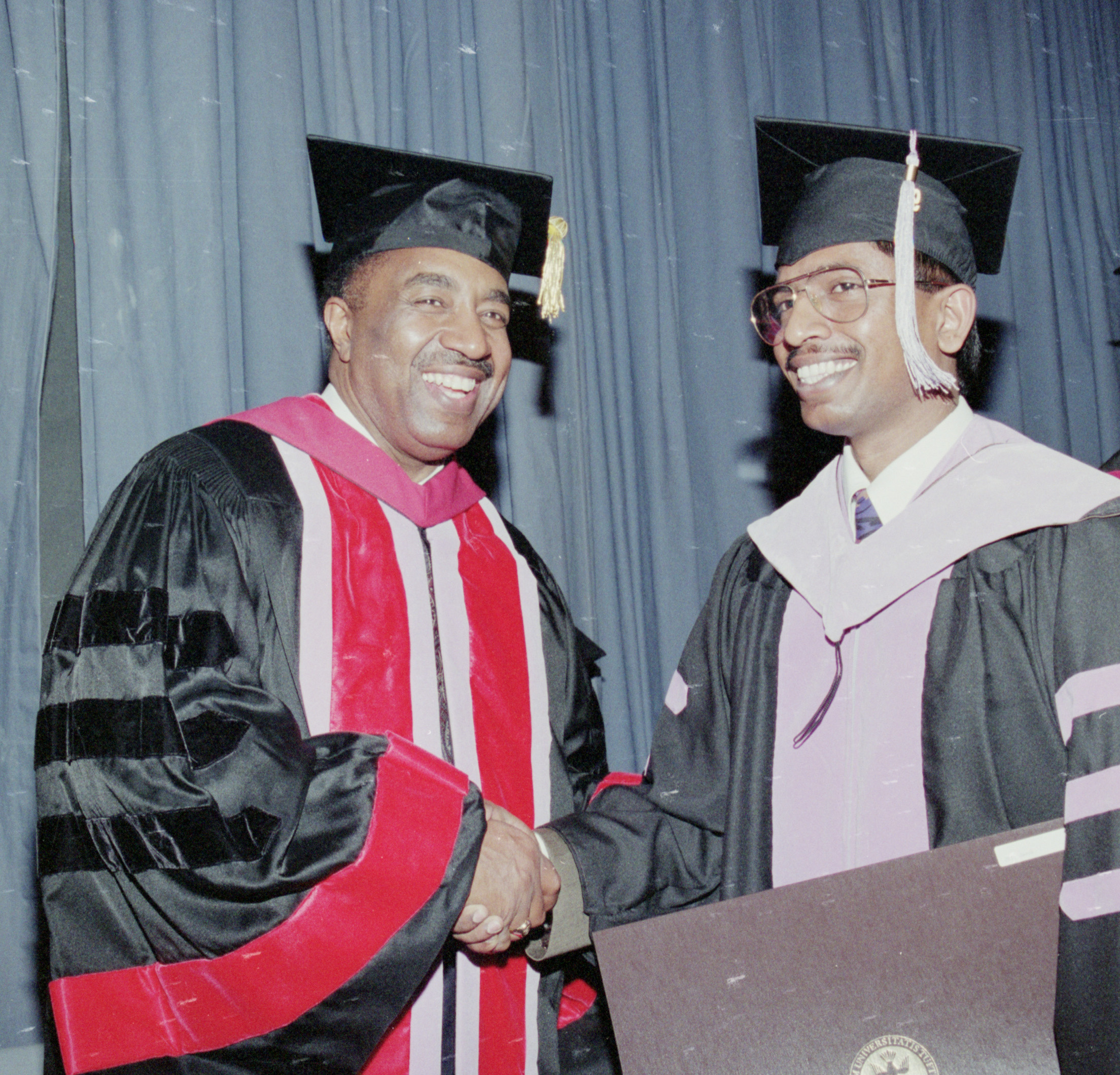 Color photo of Dean Lonnie Norris congratulating a Dental School alumnus. 